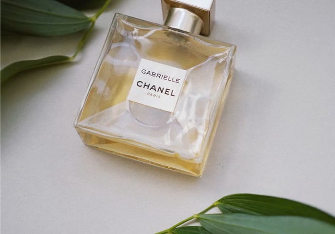 Chanel perfumes on the white background with green accents.